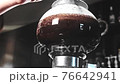 サイフォン式抽出機で抽出されたコーヒーを混ぜるシーン 76642941