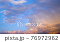 夕日に照らされる雲 76972962