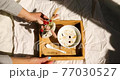 Breakfast in bed, female hands put try with bowl muesli, granola and flower in sunlight at home, chambermaid bringing tray with breakfast in hotel room, good service 77030527