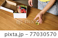 Woman put on the table food box meal kit of fresh ingredients order from a meal kit company, delivered, cooking at home. 77030570