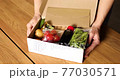 Woman open a delivery box meal kit and pulls fresh ingredients order from a meal kit company, delivered, cooking at home. 77030571