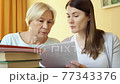 Teacher give lesson to senior student. Female tutor explain foreign language rule to senior woman 77343376