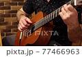 A man playing the guitar 77466963