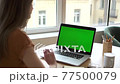 Woman talk on video call at laptop with green screen. Rear view of female sitting at desk greet 77500079