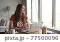 Woman sit at home and think of idea while working at laptop. Young millennial female look aside 77500096