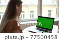 Woman talk on green screen online call and write notes in notebook. Female at business conference 77500458