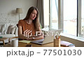 Woman start video call at home office, wave and greet conference. 20s female smile and talk to work 77501030