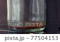 Transparent glass getting filled with fresh espresso coffee (closeup) 77504153