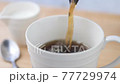 白いコーヒーカップにコーヒーを注ぐ 77729974