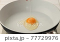 フライパンに卵を落とし目玉焼きを焼く 77729976