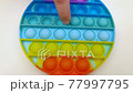 Popit antistress toy for children entertainment on a yellow background playing a child top view in colored fijit simple dimple popit silicone fidget, trendy sensory color push 77997795