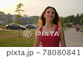 Pretty smiling beautiful young shopping woman female in red dress with bags packages walking outdoors street city 78080841