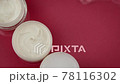 Cosmetic jars with moisturizing cream in clean water splash on red background 78116302