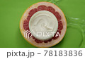 Cosmetic jar of moisturizing cream on piece of red citrus fruit in water splash 78183836