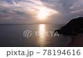 [Drone aerial photography] A cut taken aerial while rising from the beach of Okinawa toward the setting sun 78194616