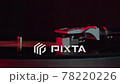 black vinyl record spinning on turntable On Neon red light LP player in motion 78220226