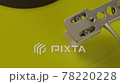 Close-up pickup head on yellow vinyl record spinning on turntable. Top view 78220228