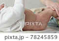 Mother hands stroking legs and body of infant with love. Close-up baby foot massage. Air Bath after diapers 78245859