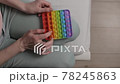 Woman plays with colored silicone antistress toy pop it 78245863