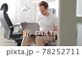 Bearded young man, working at home in living room sitting on coach with laptop. Freelancer online 78252711