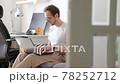 Bearded young man, working at home in living room sitting on coach with laptop. Freelancer online 78252712