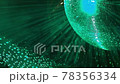 A mirrored disco ball is illuminated by a green 78356334