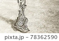 A pile of steel chains falling on a concrete floor 78362590