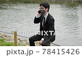 A business person masks the corona in Kawahara and calls with a smartphone 2 78415426