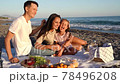 Happy family have a picnic on the beach at sunset. 78496208