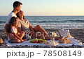 Happy family have a picnic on the beach at sunset. 78508149