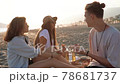 Friends having a picnic with pizza and beer on the beach at sunset. 78681737