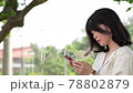 A woman touching a smartphone (from the side) 78802879