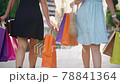 Young women walks with colorful shopping bags around shopping mall. 78841364