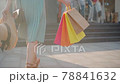 Back view of young woman's legs and colorful shopping paper bags 78841632
