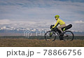 The man and woman travel on mixed terrain cycle touring with bikepacking. The two people journey with bicycle bags. Mountain snow capped. The man and woman travel on mixed terrain cycle touring with bikepacking. The two people journey with bicycle bags. Mountain snow capped. 78866756
