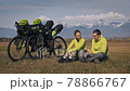 The man and woman travel on mixed terrain cycle touring with bikepacking. The two people journey with bicycle bags. Mountain snow capped. The man and woman travel on mixed terrain cycle touring with bikepacking. The two people journey with bicycle bags. Mountain snow capped. 78866767