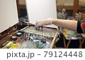 Artist girl with paints and brushes prepares her instruments to start drawing. 79124448