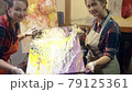 Women artists are enjoying new acrylic painting that was just made. Looking in the camera and smiling. 79125361