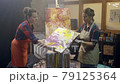 Wome artists are making acrylic paintings. Acrylic paint is spreading over the canvas. Artistic collaboration in workshop. 79125364