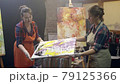 Wome artists are making acrylic paintings. Acrylic paint is spreading over the canvas. Artistic collaboration in workshop. 79125366