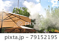 Artificial mist created by an outdoor cooling system 79152195