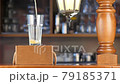 Pour beer into a transparent glass on the bar. Light, golden beer pours into a glass against the backdrop of a bar in a pub. 79185371