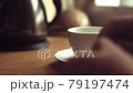 Close up. Put a tea bag into a cup. Pouring boilin 79197474