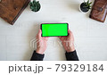 Phone with green screen on the table with notebook and purse view from top, smartphone chromakey screen copy space  79329184