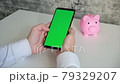 Phone with green screen and piggy Bank on white background top View . smartphone chromakey swipes in different directions. copy space 79329207