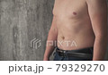 Close up fat man touch the Belly doing massage shaking. He very fat and has problem with stomach ache because he eat to much. .a man massages his stomach. fight against excess weight  79329270