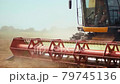 Rotary straw walker cut and threshes ripe wheat grain. Man in combine harvesters with grain header, wide chaff spreader reaping cereal ears. Gathering crop by agricultural machinery on field in summer 79745136