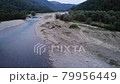 Aerial flying over herd of cows grazing in a pasture by the river. Taken by drone, fly past 79956449