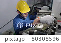 An Asian male engineer is inspecting and repairing machines in the factory. Engineering and industrial concept.	 80308596
