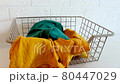 Dirty laundry is thrown into laundry basket.  80447029